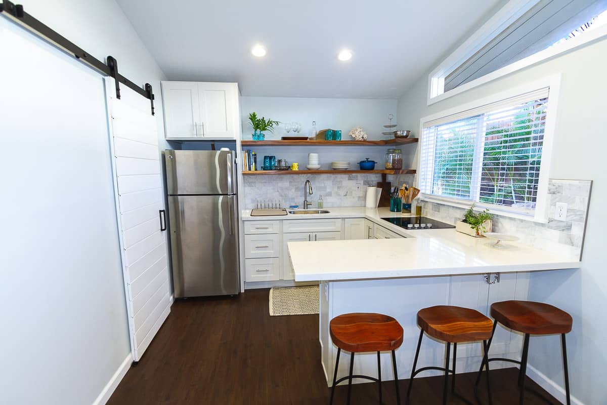 kitchen with quarts countertop, floating shelves and barn door.