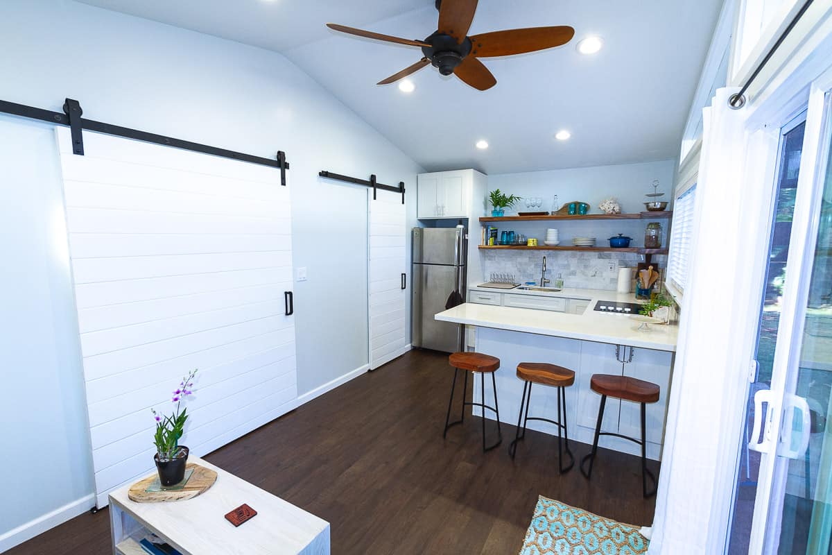 White barn doors and view of kitchen.